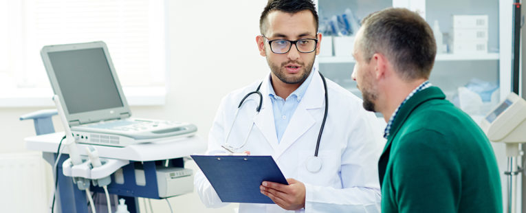 middle-aged man talks to doctor about prostate exams