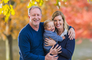 Rick and Angela Farnan along with their son, Blaze standing outside in autumn.