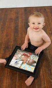艾略特宝宝带着自己刚出生时的照片在家里
