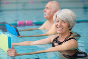 senior woman and man exercising in a pool