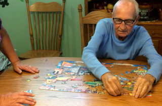 Harry and Terry Alexander putting a jigsaw puzzle together in their dining room