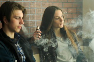 十几岁的男孩和女孩在吸电子烟