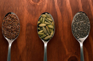 Flax seeds, pumpkin seeds, and chia seeds on spoons