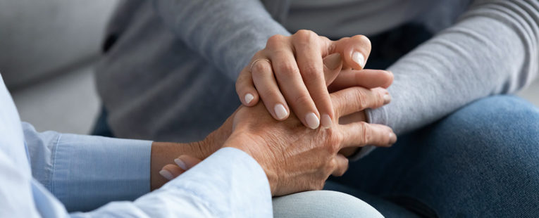 Grief support group participants holding hands
