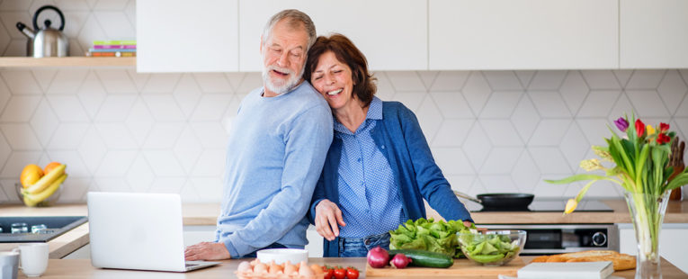 Senior couple cooking healthy food in kitchen.