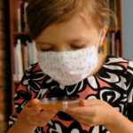 6-year-old coughs into petri dish with a face mask on in germ experiment