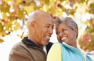 Active African-American senior couple in a warm embrace on an autumn day.