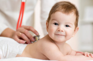 A doctor performs a newborn screening on a young baby.