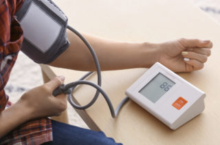 Young woman measuring his blood pressure at home