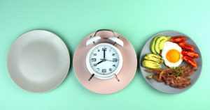 empty dinner plate and plate with food. Clock in the middle