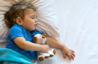 小男孩和毛绒动物一起睡觉。