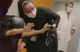 修女佩塔和一个孩子展示了虚拟现实的使用。
