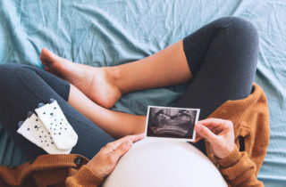 pregnant woman looking at ultrasound trimester