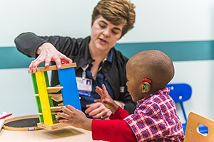Pediatric rehabilitation specialist working with young boy