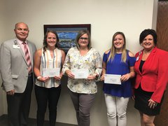 Ken Beutke (L), president of OSF Saint Elizabeth, and Cherie Reynolds (R), director of development with OSF Foundation, present the recipients (L:R) McKenna Campbell, Sandy Northcutt, and Maleah Greene with the 2019 educational loan assistance awards.
