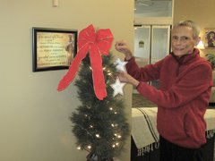 Deb Kirley, Tree of Lights chairperson, hangs a star in honor of a loved one